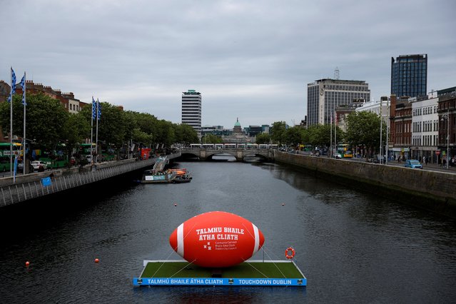A giant American football floats on a pontoon on the river Liffey, ahead of a game of American football between K-State and Iowa State being held at the Aviva Stadium, in Dublin, Ireland, on July 4, 2025. (Photo by Clodagh Kilcoyne/Reuters)