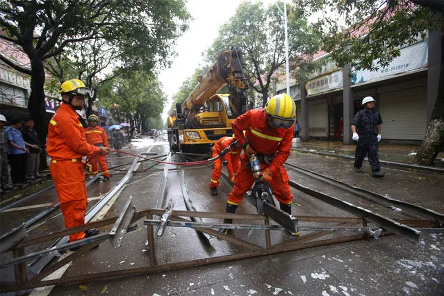 Rescue workers try to remove steel bars from a street as Typhoon Megi hits Xiamen, Fujian province, China, September 28, 2016. (Photo by Reuters/Stringer)