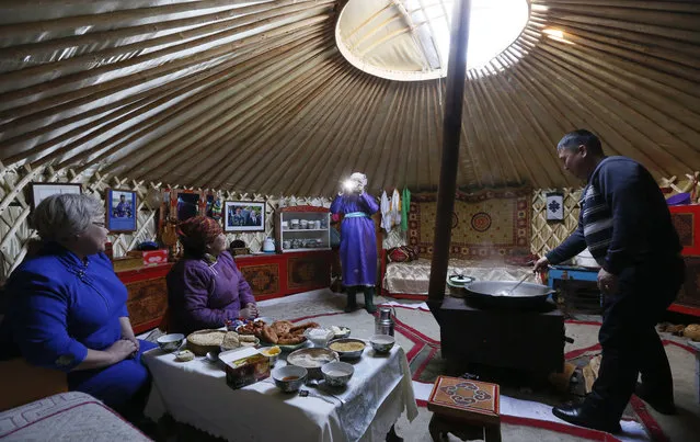 Tanzurun Darisyu (2nd L) has a meal together with her neighbors and relatives inside a yurt south of Kyzyl town in the Republic of Tuva on February 14, 2018. (Photo by Ilya Naymushin/Reuters)