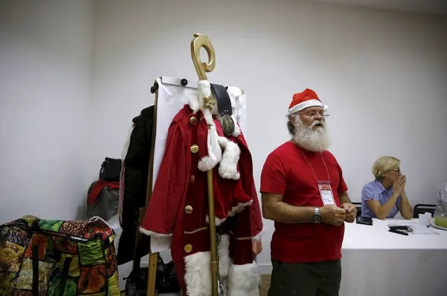A student of the "Escola de Papai Noel do Brasil" (Brazil's school of Santa Claus) stands next to a Santa Claus costume during lessons in Rio de Janeiro, Brazil, October 27, 2015. The school, which was founded since 1993, prepare men to represent Santa Claus during the Christmas season. Lessons include singing, physical activity, how to dress and how to care for their beard. (Photo by Pilar Olivares/Reuters)