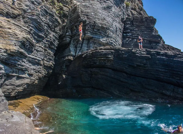 “Italian boys try to out dive each other from the cliffs of Vernazza, in Liguria. I sat watching them attempt more and more daring dives. Their showmanship had me captivated for an hour as I sat on the rocks … not quite brave enough to join them”. (Photo by Eddie Smith/The Guardian)
