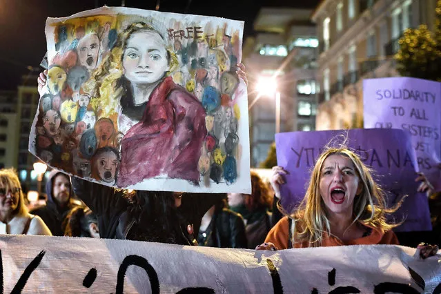 People hold banners and placards as they take part in a march marking International Women's Day in Athens, Greece on March 8, 2018. (Photo by Louisa Gouliamaki/AFP Photo)