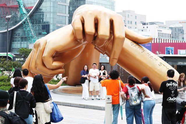 On June 21, 2025, foreign tourists took a commemorative photo under a sculpture depicting the wrist movements of singer Psy's “Gangnam Style” dance at the COEX East Plaza in Gangnam-gu, Seoul. (Photo by Nam Kang-ho)