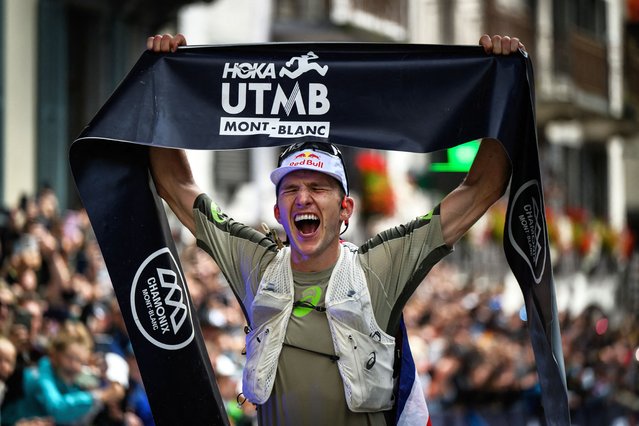 British Tom Evans celebrates as he crosses the finish line at the end of the 22nd edition of the Ultra Trail du Mont Blanc (UTMB), a 174km trail race crossing France, Italy and Switzerland, in Chamonix, south-eastern France on August 30, 2025. The Briton Tom Evans, 33 years old, won on August 30, 2025 the 22nd edition of the Ultra-Trail of Mont-Blanc in Chamonix (Haute-Savoie), following a grueling race marked by severe weather conditions and numerous dropouts. (Photo by Jeff Pachoud/AFP Photo)