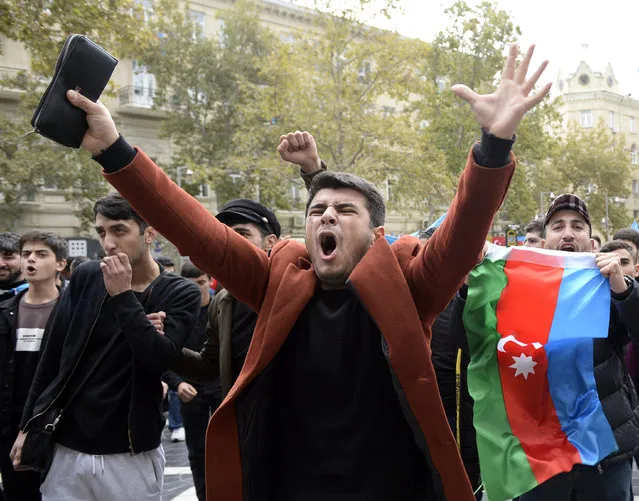 Azerbaijanis celebrate with national flags in Baku, Azerbaijan, Tuesday, November 10, 2020. Armenia and Azerbaijan announced an agreement early Tuesday to halt fighting over the Nagorno-Karabakh region of Azerbaijan under a pact signed with Russia that calls for deployment of nearly 2,000 Russian peacekeepers and territorial concessions. (Photo by AP Photo/Stringer)