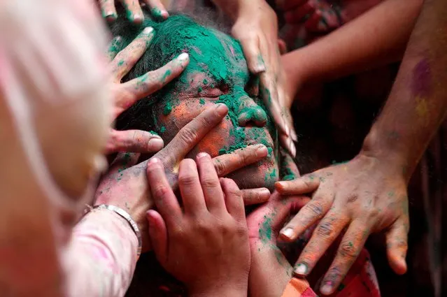 People smear coloured powder on a woman during Holi celebrations in Mumbai, India on March 7, 2023. (Photo by Francis Mascarenhas/Reuters)