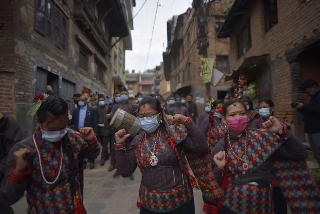 Newari people dance in a traditional tunes along with the face mask during the parade of Nhu Dan the Newari New Year, which falls on Tihar or Deepawali and Dewali Festival of Lights at Kirtipur, Kathmandu, Nepal on Monday, November 16, 2020. Only limited numbers of people from Newar community joined due to covid pandemic in Newari New Year 1141 parade. (Photo by Narayan Maharjan/NurPhoto via Getty Images)
