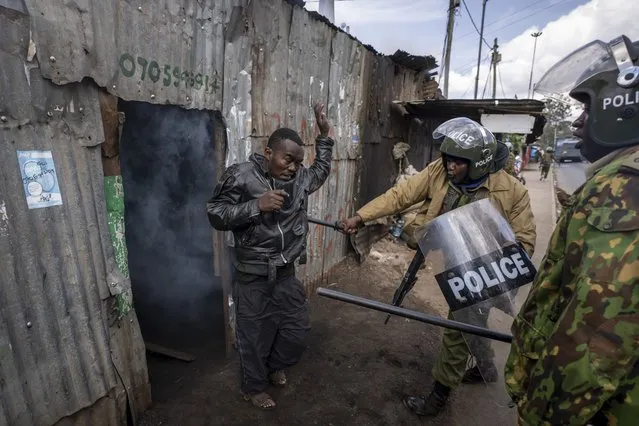Police beat a protester who had hidden in a shack, after police threw a tear gas grenade inside to force him out, in the Kibera slum of Nairobi, Kenya Monday, March 20, 2023. (Photo by Ben Curtis/AP Photo)