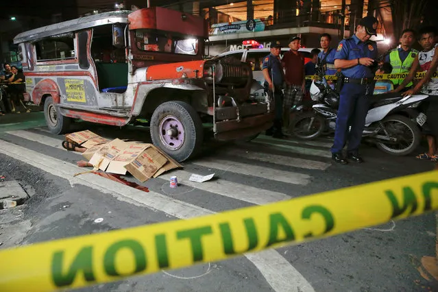 The body of a man killed by unknown gunmen is covered in Manila, Philippines early October 18, 2016. (Photo by Damir Sagolj/Reuters)