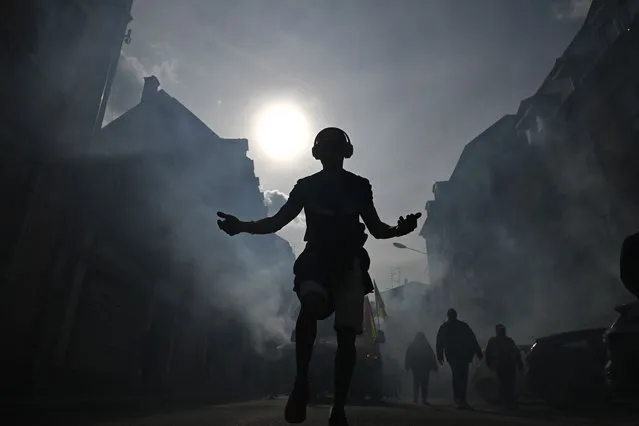 A man dances during a demonstration on a 8th day of strikes and protests across the country against the government's proposed pensions overhaul in Mulhouse, eastern France on March 15, 2023. France faces another day of strikes over highly contested pension reforms which President appears on the verge of pushing through despite months of protests. As the legislation enters the final stretch in parliament, trade unions are set to make another attempt to pressure the government and lawmakers into rejecting the proposed hike in the retirement age to 64. (Photo by Sébastien Bozon/AFP Photo)