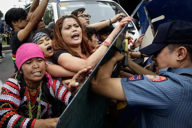 Filipino protesters scuffle with police during a protest in front of the US Embassy in Manila, Philippines, October 19, 2016. Hundreds of protesters including Indigenous People, students and militant groups stormed toward the US Embassy to protest against the presence of US military troops and to support Philippine President Rodrigo Duterte's independent foreign policy pronouncements. The protest ended violently as the protesters clashed with the police during the dispersal. Initial reports said at least five protesters and around thirty police officers were hurt. (Photo by Mark R. Cristino/EPA)