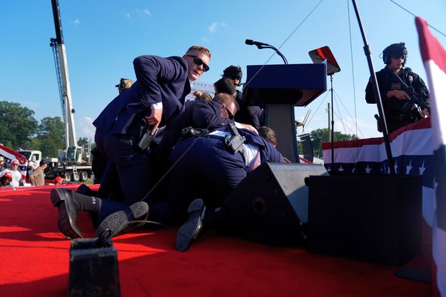 Republican presidential candidate former President Donald Trump is surrounded by U.S. Secret Service agents at a campaign rally, Saturday, July 13, 2024, in Butler, Pa. (Photo by Evan Vucci/AP Photo)