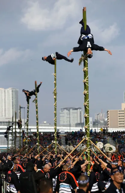 Members of a traditional firefighting preservation group perform ladder stunts during the annual New Year's Fire Brigade Review in Tokyo, Tuesday, January 6, 2015. (Photo by Eugene Hoshiko/AP Photo)