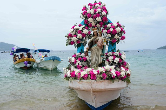 A boat decorated with a statue of the Virgen del Carmen is pictured before an ocean procession in Taboga island, near Panama City on 16, 2024. Every July 16, Fishermen attend an ocean procession honouring the day of the Virgen del Carmen which Catholics consider as the patron saint of fishermen and sailors. (Photo by Arnulfo Franco/AFP Photo)