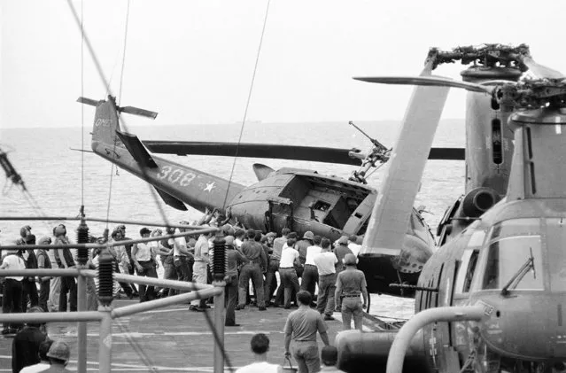 A South Vietnamese helicopter is jettisoned overboard from the USS Blue Ridge somewhere off Vietnam, April 30, 1975. The helicopter was one of those discarded from the ship because of damaged condition or to make room for others attempting to land. The aircraft still bears its old U.S. military markings. (Photo by AP Photo)