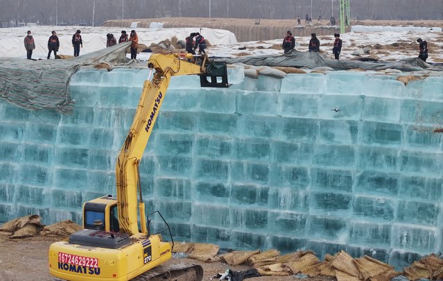 An excavator transfers stored ice to be used in the constructions of ice-built landscapes for the 27th Harbin Ice-Snow World on November 24, 2025 in Harbin, Heilongjiang Province of China. The 27th Harbin Ice-Snow World will roll out a slate of new attractions this year to draw visitors, such as hot spring camps, cross-country skiing tracks, themed parades and a variety of ice-and-snow activities. (Photo by Zhang Shu/VCG via Getty Images)