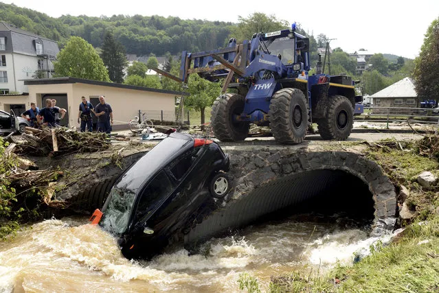 A car is pulled out of the floods in the small city of Herrstein, southern Germany, Monday, May 28, 2018. Heavy rain on the evening before caused flooding destroying big parts of the village. (Photo by Harald Tittel/DPA via AP)