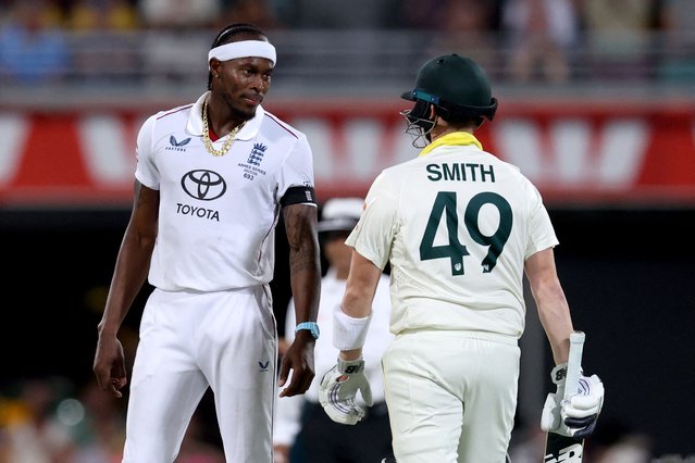 Australia's captain Steve Smith (R) reacts with England's Jofra Archer on day four of the second Ashes cricket Test match between Australia and England at The Gabba in Brisbane on December 7, 2025. (Photo by David Gray/AFP via Getty Images)
