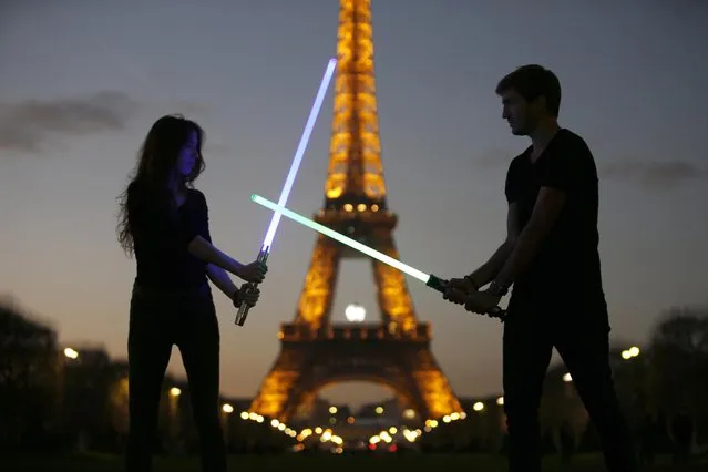 Marion (L) and Nikola (R), members of the Sport Saber League, pose with their light sabers in front of the Eiffel tower in Paris, France, November 26, 2015. (Photo by Charles Platiau/Reuters)