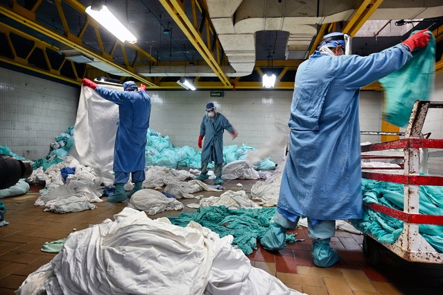 Workers handle dirty laundry from the COVID-19 zone, in the laundry room of the Mexican Institute of Social Security (IMSS), in Mexico City on September 10, 2020. Cleaning workers also risk their lives in Mexico's pandemic hospitals, knowing that their efforts often go unnoticed. (Photo by Alfredo Estrella/AFP Photo)