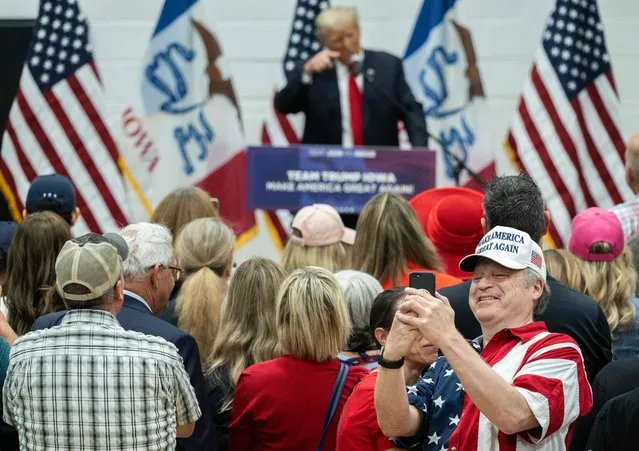 A person takes a photo as former US President and 2024 Presidential hopeful Donald Trump speaks during a Team Trump Volunteer Leadership Training at the Grimes Community Center in Grimes, Iowa, on June 1, 2023. (Photo by Andrew Caballero-Reynolds/AFP Photo)