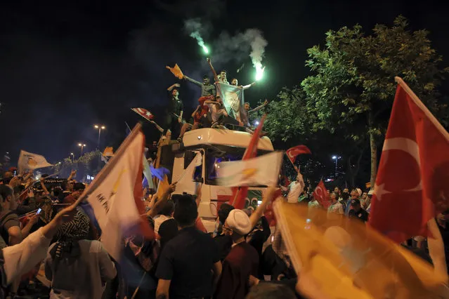 Supporters of Turkey's President and ruling Justice and Development Party, or AKP, leader Recep Tayyip Erdogan celebrate atop a truck outside the party headquarters in Istanbul, Sunday, June 24, 2018. Unofficial results from Turkey's presidential election show incumbent Recep Tayyip Erdogan with a commanding lead. (Photo by AP Photo/Stringer)