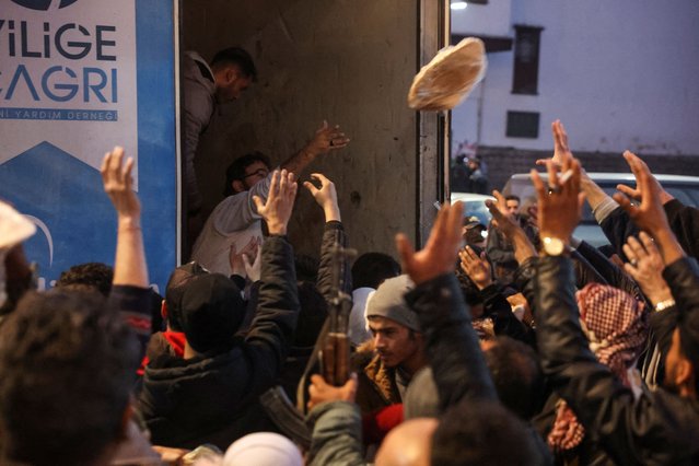 People gather to receive flatbread, after rebels seized the capital and ousted Syria's Bashar al-Assad, in Damascus, Syria on December 9, 2024. (Photo by Mohamed Azakir/Reuters)