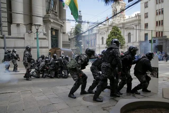 Riot police take position during a protest of healthcare workers against new government measures amidst the coronavirus disease (COVID-19) outbreak, in La Paz, Bolivia, February 23, 2021. Conasa (National Health Council) called for a strike last friday after President Luis Arce passed an emergency law. (Photo by David Mercado/Reuters)