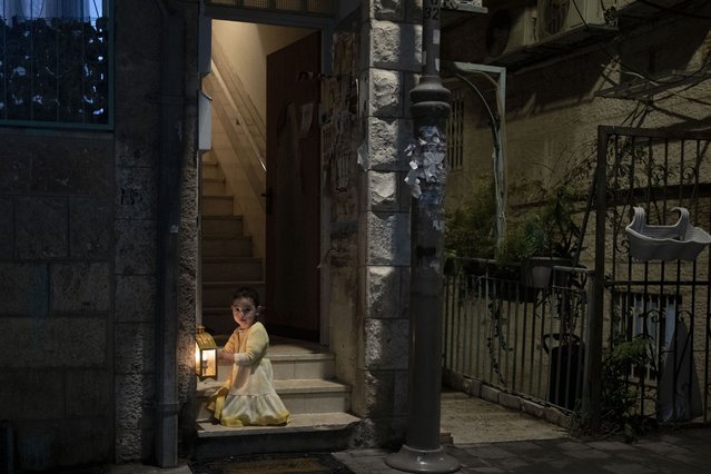 An ultra-Orthodox Jewish girl looks at her family's candles, lit to mark the Jewish holiday of Hanukkah in Jerusalem, Wednesday, January 1, 2025. (Photo by Maya Alleruzzo/AP Photo)