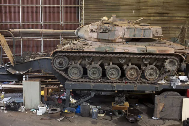 An engine-less tank sits on a truck platform inside a warehouse in Sao Paulo, Brazil, Tuesday, January 27, 2015. Brazilian police say a raid to recover stolen cars and cargo came up with the two war tanks. Police also confiscated 500 television sets, car body parts and a recently stolen semitrailer truck. Army officers told the UOL Internet portal that the two tanks did not belong to the Army and that their origin would be investigated. (Photo by Andre Penner/AP Photo)