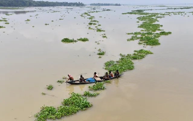 Indian villagers paddle a boat in flood-affected Ashigarh village in Morigoan district, in India's northeastern state of Assam, on July 6, 2018. Heavy monsoon rains bring floods to parts of northeastern India each year, affecting the lives of millions of people. (Photo by Biju Boro/AFP Photo)