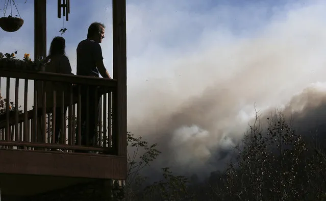 Eric and Vebbra Willey watch from their porch as the Rock Mountain wildfire approaches closer to their home on Wednesday, November 16, 2016, in Tate City, Ga. Residents are under a pre-evacuation order as firefighters work to keep the fire away from homes. (Photo by Curtis Compton/Atlanta Journal-Constitution via AP Photo)