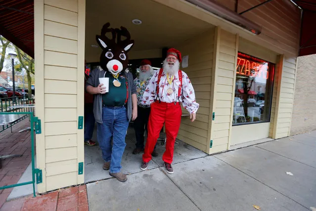 Rudolph walks out of Pizza Sam's with fellow Santas on Main Street during a lunch break from class at  Charles W. Howard Santa Claus School in Midland, Michigan, U.S. October 27, 2016. (Photo by Christinne Muschi/Reuters)