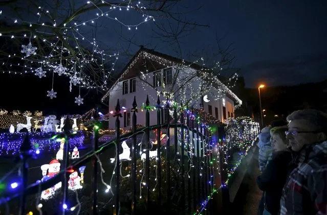 People look at a house decorated with Christmas lighting in the town of Benesov nad Ploucnici, Czech Republic, December 22, 2015. (Photo by David W. Cerny/Reuters)