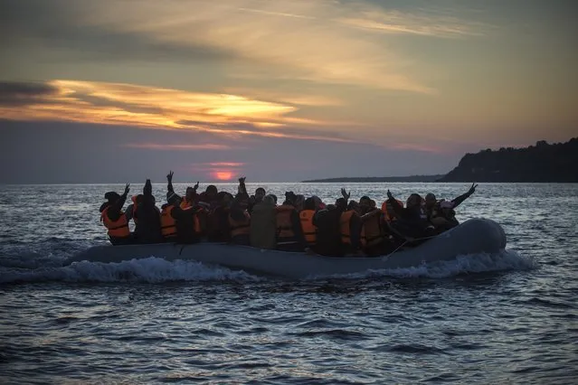 Refugees and migrants calls the attention of a rescue team when approaching the Greek island of Lesbos on a dinghy, after crossing a part of the Aegean sea from Turkey, on Friday, December 25, 2015. The International Organization for Migrants said more than 1 million people have entered Europe earlier this week. Almost all came by sea, while 3,692 drowned in the attempt. (Photo by Santi Palacios/AP Photo)