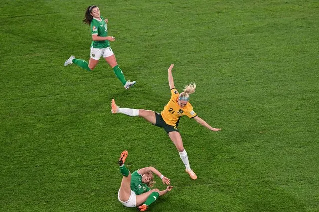 Australia's defender #21 Ellie Carpenter (C) and Ireland's midfielder Ruesha Littlejohn (bottom) collide during the Australia and New Zealand 2023 Women's World Cup Group B football match between Australia and Ireland at Stadium Australia, also known as Olympic Stadium, in Sydney on July 20, 2023. (Photo by Izhar Khan/AFP Photo)