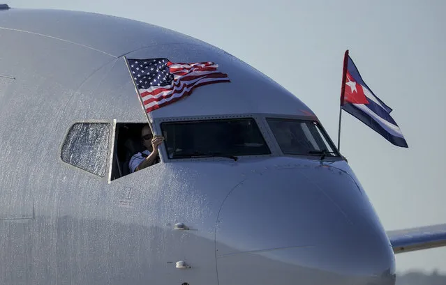 An American Airlines plane fluttering US and Cuba national flags is seen uppon arrival at Jose Marti International Airport becoming the first Miami-Havana commercial flight in 50 years, coinciding with the beginning of the tributes to late Cuban leader Fidel Castro, on November 28, 2016 in Havana. (Photo by Yamil Lage/AFP Photo)