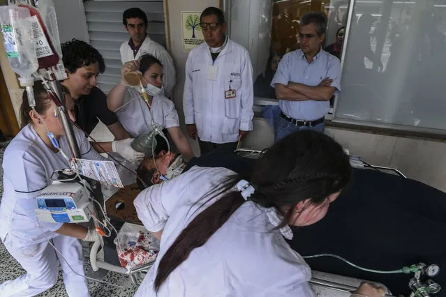 Brazil's Chapecoense player Helio Neto is helped by paramedics at the San Juan de Dios clinic in La Ceja, Antioquia Department on November 29 2016. Traveling on the doomed airliner that crashed in Colombia overnight were the players and staff of a Brazilian football club about to complete a fairytale journey from unknowns to would-be South American champions. The LAMIA charter plane went down near Medellin late Monday with 81 people aboard and so far only six are reported to have survived. At least two were said by officials to be football players. (Photo by Luis Acosta/AFP Photo)