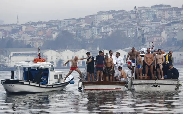 Greek Orthodox faithful wait for the Greek Orthodox Ecumenical Patriarch Bartholomew I (not pictured) to throw a wooden crucifix into the Golden Horn in Istanbul, Turkey, January 6, 2016. Greek Orthodox faithful swam to retrieve the wooden crucifix thrown by Greek Orthodox Ecumenical Patriarch Bartholomew I into the Golden Horn in Bosphorus during Epiphany Day celebrations. (Photo by Murad Sezer/Reuters)