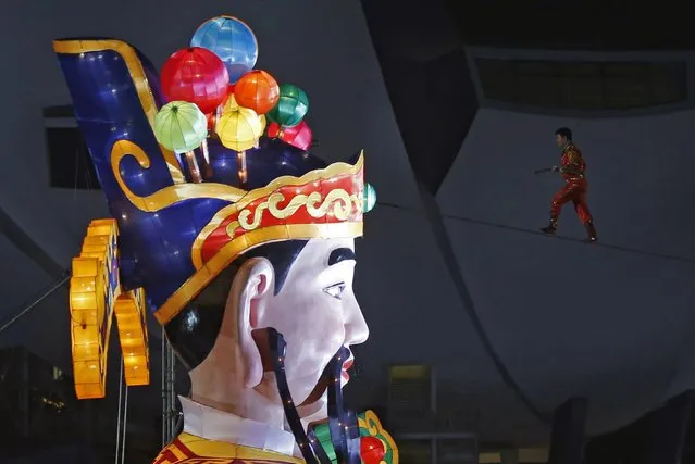 Member of the Acrobatic Troupe of Xinjiang Adili Wuxor walks the tightrope past a God of Fortune statue during an aerial performance at the River Hongbao Lunar New Year Celebrations along Marina Bay in Singapore February 17, 2015. (Photo by Edgar Su/Reuters)