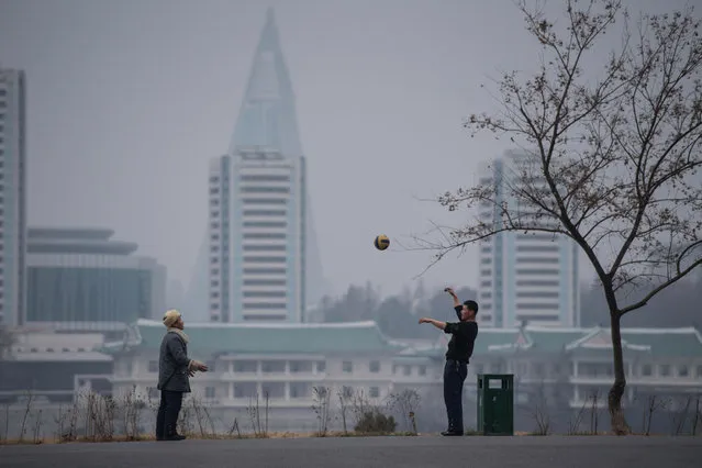 Two men throw a ball to each other in Pyongyang on November 26, 2016. (Photo by Ed Jones/AFP Photo)