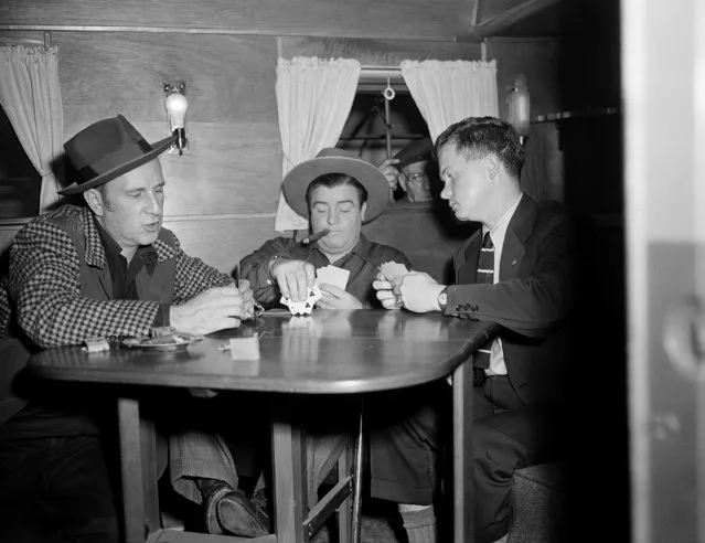 Associated Press journalist Bob Thomas plays cards on set with Abbott and Costello, Los Angeles, March 2, 1945. (Photo by AP Photo)