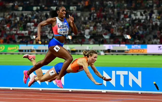 Spot the baton: the Dutch athlete Femke Bol falls to the ground as Alexis Holmes of the US runs to victory in the mixed 4x400m relay final at the World Athletics Championships in Budapest, Hungary on August 19, 2023. (Photo by Márton Mónus/Reuters)