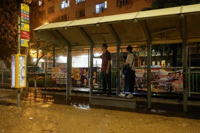 People wait the bus at a flooded area during heavy rain in Hong Kong, China on September 8, 2023. (Photo by Tyrone Siu/Reuters)