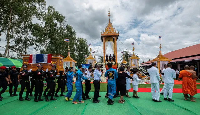 Military personnel carry the coffin of Samarn Kunan, a former Thai navy diver who died working to rescue a young soccer team trapped for days in a flooded cave, during his funeral at a temple in Roi Et province, Thailand, July 14, 2018. (Photo by Reuters/Stringer)