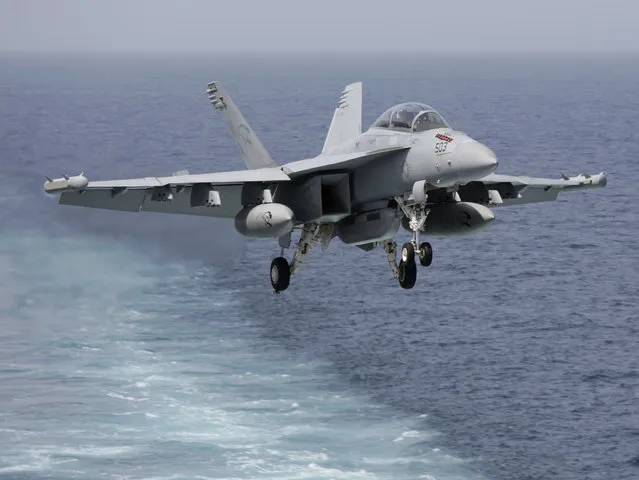 A U.S. military plane approaches to land on the flight deck of the USS Carl Vinson aircraft carrier in the Persian Gulf, Thursday, March 19, 2015. (Photo by Hasan Jamali/AP Photo)