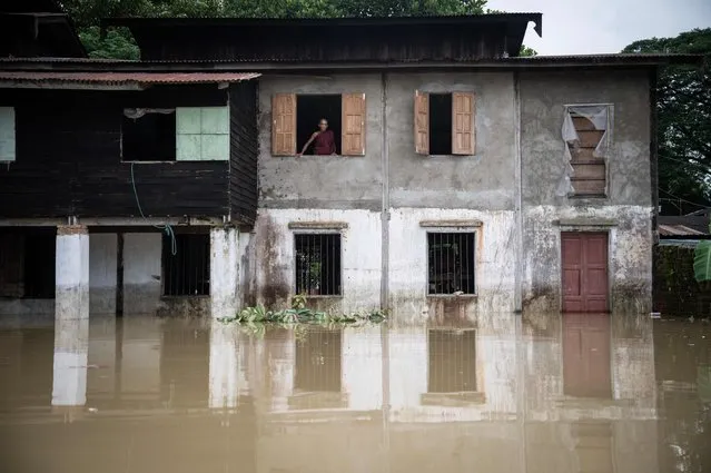 A Buddhist monk looks out from a monastery in a flooded area of Bago township in Myanmar's Bago region on August 12, 2023. Floods and landslides caused by monsoon rains have killed five people and forced the evacuation of around 40,000 others in Myanmar, officials said on August 11. (Photo by Sai Aung Main/AFP Photo)