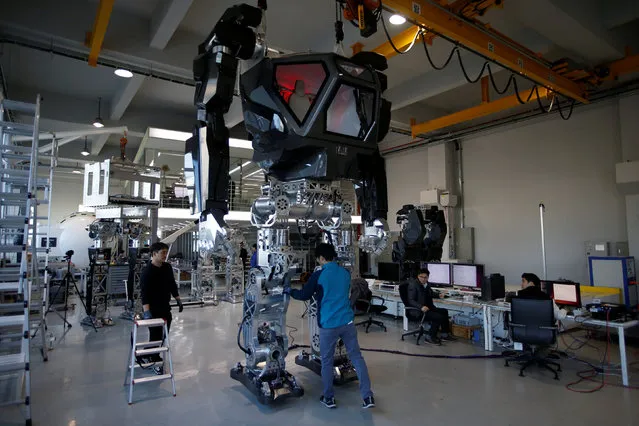 Employees check a manned biped walking robot “METHOD-2” during a demonstration in Gunpo, South Korea, December 27, 2016. It stands 13-feet (3,96 m) tall, weighs 1.3 tons and wields a pair of 286-pound (129,73 kg), motion-tracking metal arms. “Our robot is the world's first manned bipedal robot and is built to work in extreme hazardous areas where humans cannot go (unprotected)”, Hankook Mirae Technology company chairman, Yang Jin-Ho, said in a prepared statement. The company has spent upwards of $200 million since 2014 to develop the mech with the help of Hollywood SFX designer, Vitaly Bulgarov, whose credits include Transformers, Robocop and Terminator. The Method-2 itself likely won't be employed in the field anytime soon. Instead, the giant machine will serve as a testbed for emerging mech technologies. Future iterations, however, could find use in everything from construction and cargo loading to military and SAR operations. (Photo by Kim Hong-Ji/Reuters)