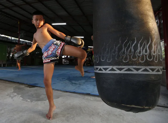 In this Wednesday, November 14, 2018, photo, Thai kickboxer Chaichana Saengngern, 10-years old, practices kicks at a training camp in Bangkok, Thailand. Thai lawmakers recently suggested barring children younger than 12 from competitive boxing, but boxing enthusiasts strongly oppose the change. They say the sport is part of Thai culture and gives poor families the opportunity to raise a champion that will lift their economic circumstances. (Photo by Sakchai Lalit/AP Photo)