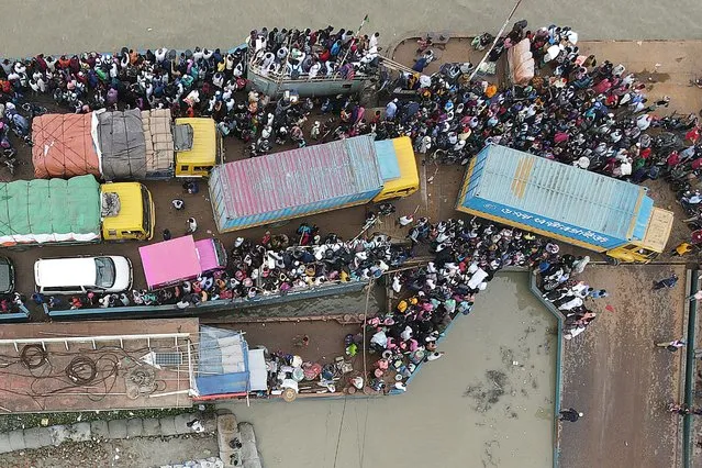 In this aerial photo taken on June 27, 2021, people board a ferry as authorities ordered a new lockdown to contain the spread of the Covid-19 coronavirus, in Munshiganj. (Photo by Munir Uz Zaman/AFP Photo)